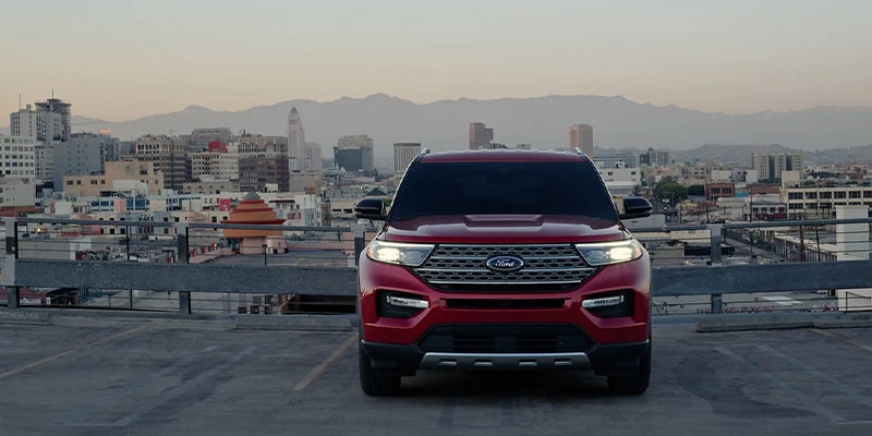 A red 2023 Ford Explorer blaring its headlights at dawn.