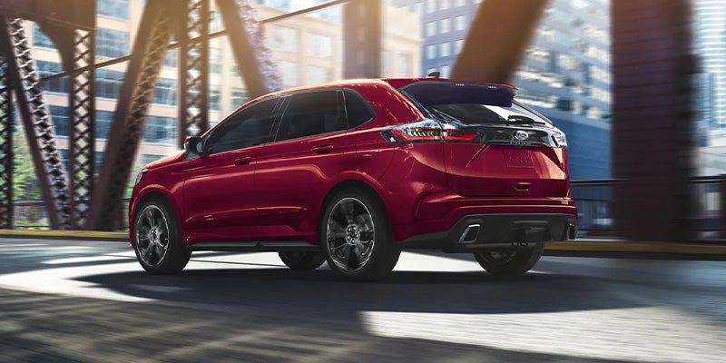 A red 2023 Ford Edge driving over a bridge.