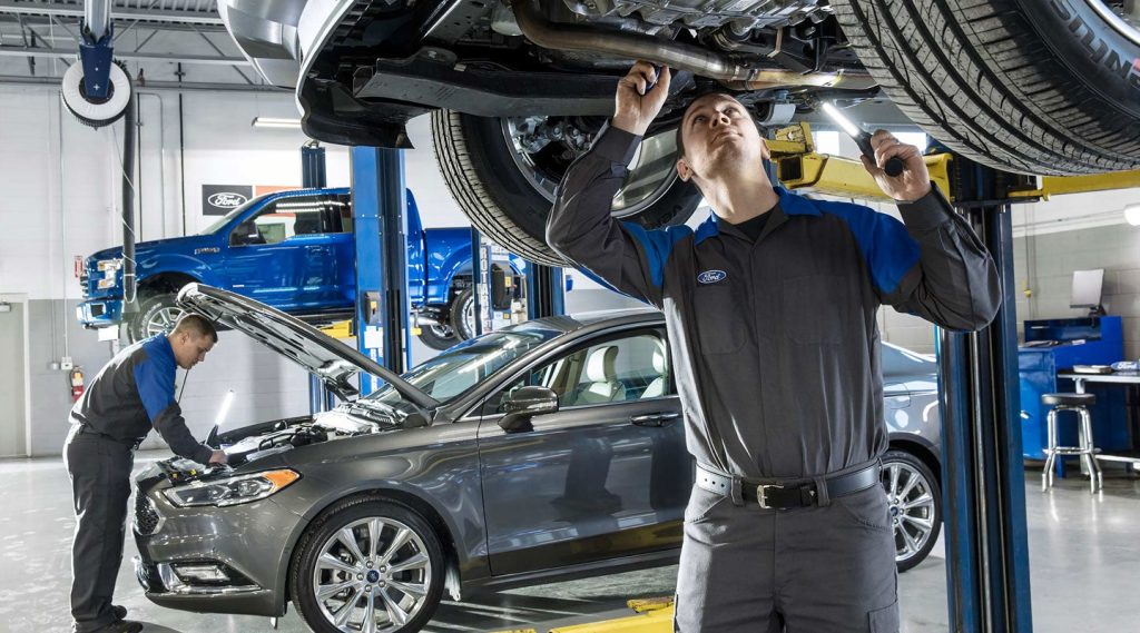 A Ford technician working on a vehicle.