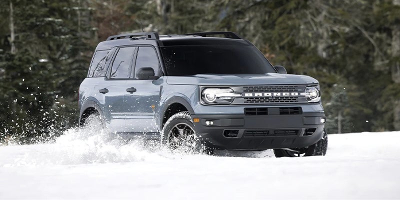 Gray Ford Bronco Sport driving through deep snow.